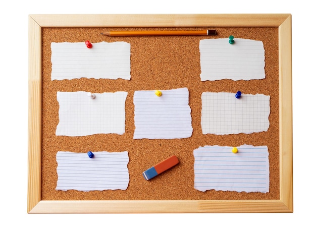 Foto tablero de notas de corcho con marco de madera con chinchetas con varias hojas de notas rotas en blanco aisladas