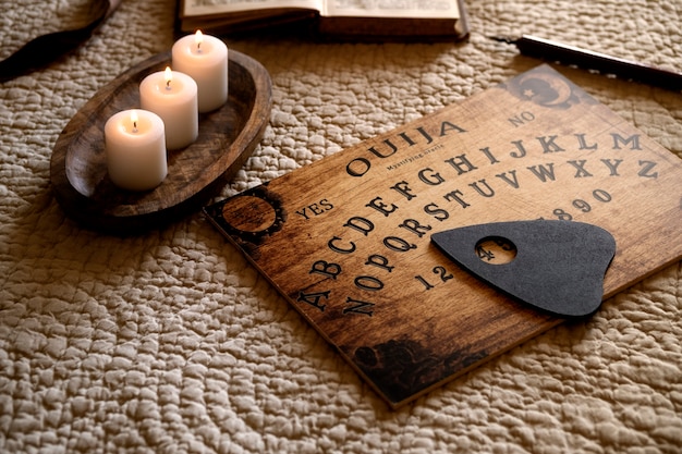 Foto tablero de ouija de madera y velas encendidas ángulo alto