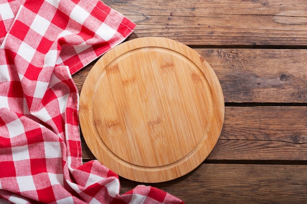 Tablero de pizza vacía en la mesa de madera, vista superior