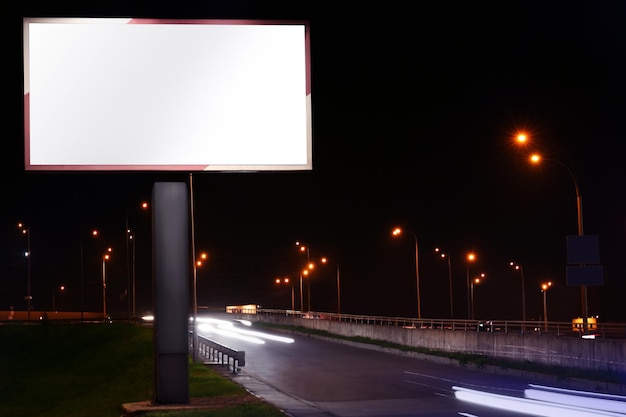 Tablero de publicidad en blanco en la calle por la noche