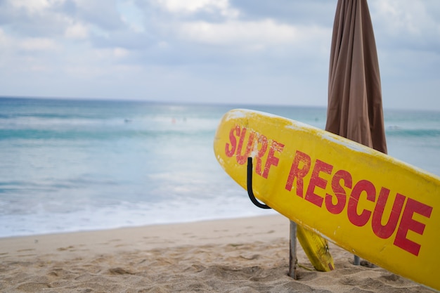 Tablero de rescate de surf amarillo en la playa