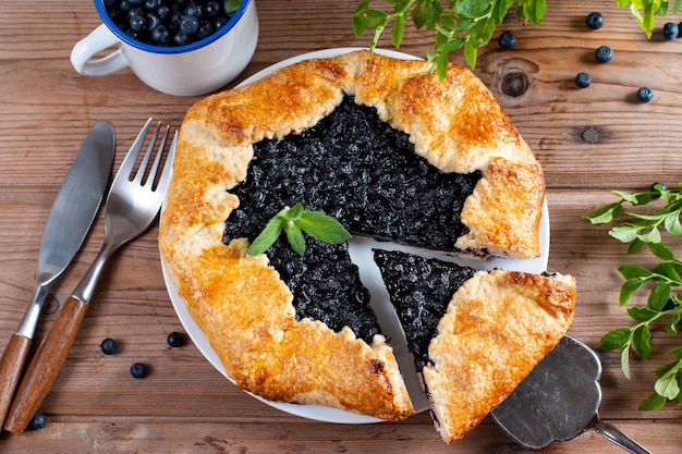 Foto tablero con sabrosa galette de arándanos en la mesa