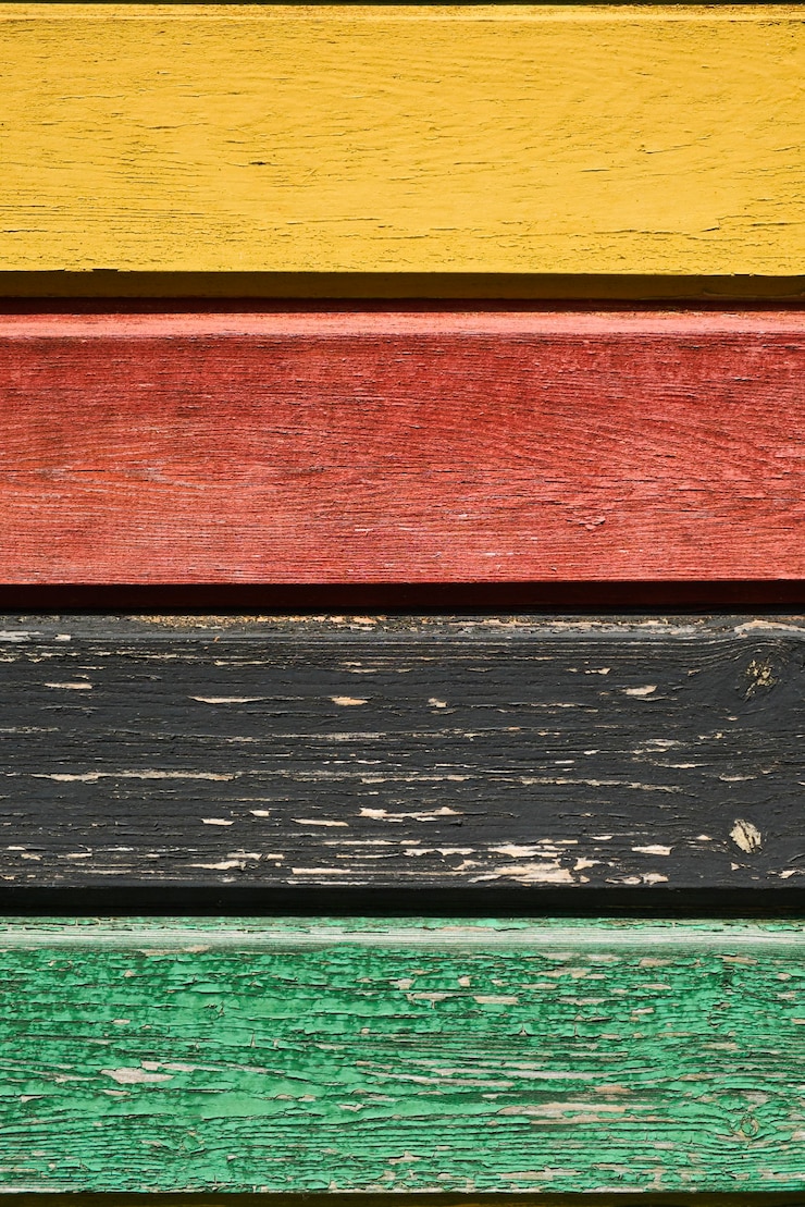 Foto tableros rugosos de varios colores amarillo rojo negro y verde pintura descascarada textura de madera colores descoloridos