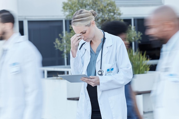 Foto tablet-arzt und frau mit stress im geschäftigen krankenhaus, müdigkeit und burnout. technischer mediziner und person mit problemkrise oder herausforderung, kopfschmerzen und angst vor fehlern, versagen oder unfällen