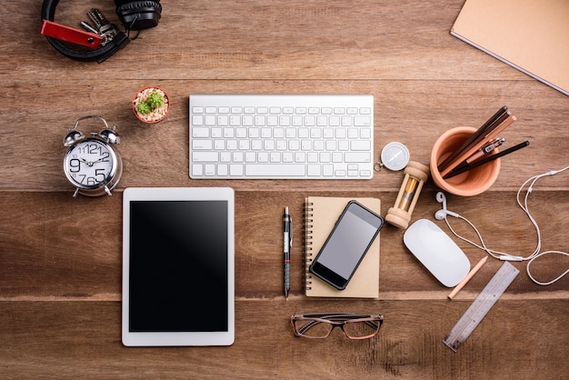 Tablet branco com tela em branco na mesa de madeira com objetos de papelaria, vista superior