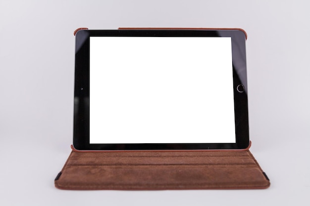 Tablet com tela branca na mesa no escritório em fundo branco