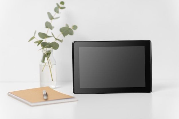tablet com tela preta em mesa de escritório branca