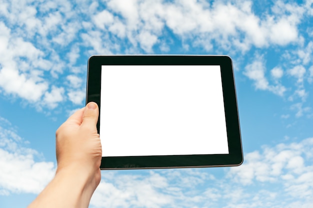 Foto tablet de close-up na mão contra o fundo do céu.