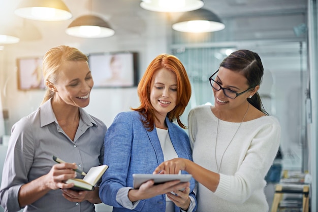 Tablet de colaboração e estratégia com uma equipe de negócios fazendo pesquisas juntos em seu escritório no trabalho Planejamento de trabalho em equipe e parceria corporativa com um grupo de funcionárias trabalhando online