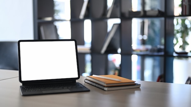 Tablet de computador e notebooks na mesa de madeira em um escritório moderno.