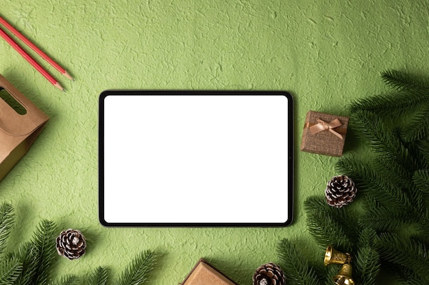 Tablet de maquete de tela em branco no Natal verde.