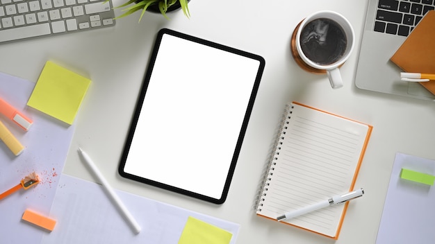 Tablet de tela em branco branco de espaço de trabalho e mesa de escritório criativa vista superior de vários equipamentos.