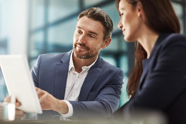 Tablet de trabalho em equipe e planejamento com empresários no escritório para pesquisa sobre um projeto da empresa Tecnologia de colaboração e brainstorming com uma equipe corporativa falando sobre estratégia no trabalho