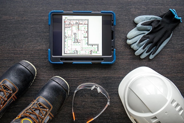 Tablet digital com layout e vista superior de roupas de trabalhador