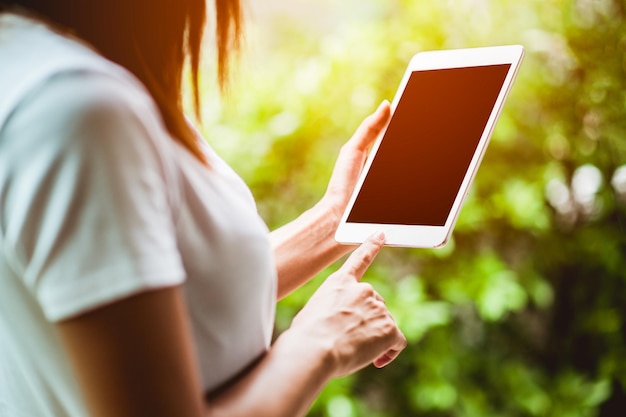 tablet digital e smartphone, as mãos do homem digitando a mensagem no tablet touch screen enquanto está sentado no terraço da varanda, clarão de sol