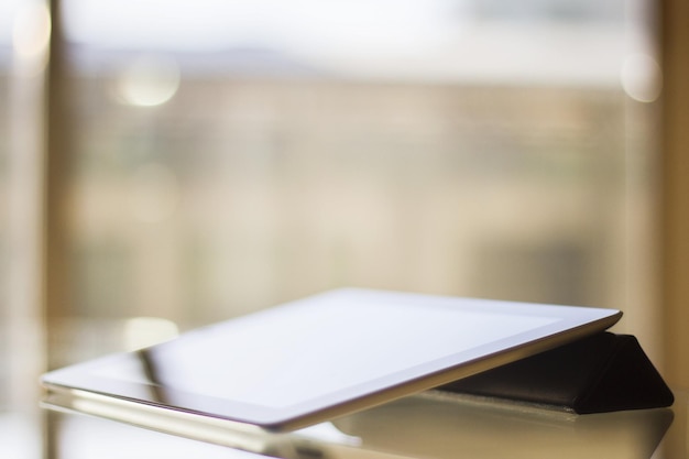 Tablet digital em uma mesa de vidro ao pôr do sol