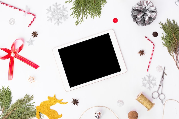 Tablet-Display auf dem Tisch mit isolierten weißen Bildschirm für Mockup in der Weihnachtszeit