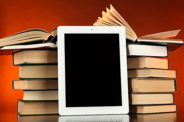 Foto tablet e livros em fundo brilhante
