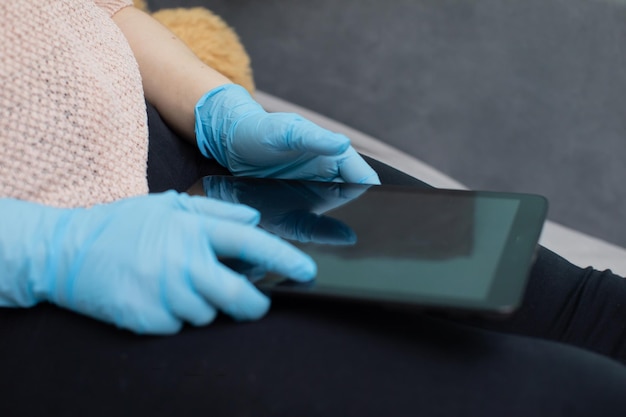 Tablet em conformidade com os regulamentos aplicáveis suportado em luvas de borracha para maior segurança