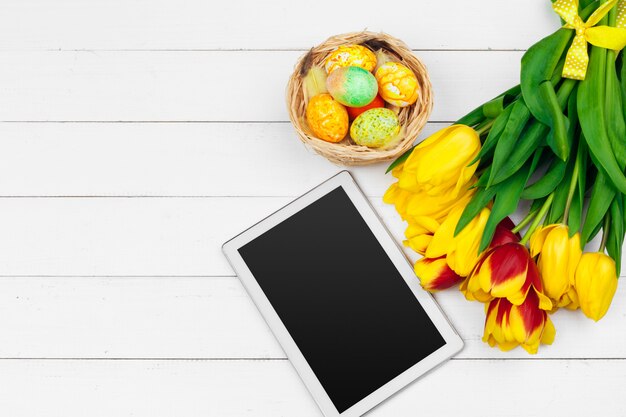 Tablet, flores de tulipa colorida e ovo de Páscoa