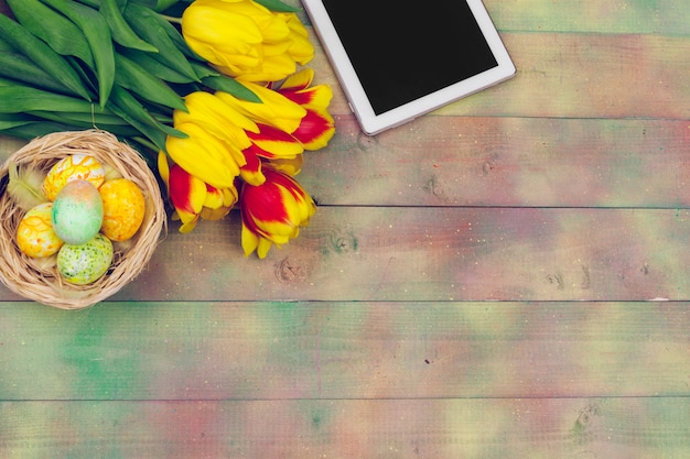 Tablet, flores de tulipa colorida e ovo de Páscoa