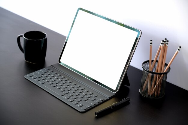 Tablet mit intelligentem tastaturfall mit leerem bildschirm auf dunkler hölzerner tabelle