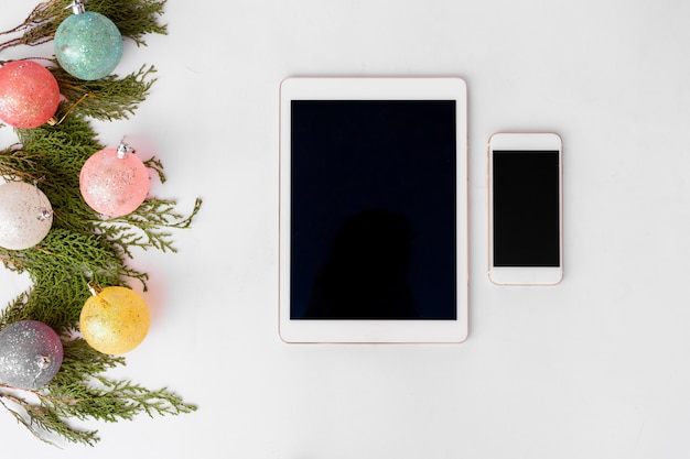 Tablet Smartphone mobile Anzeige auf dem Tisch mit isolierten weißen Bildschirm für Mockup in der Weihnachtszeit