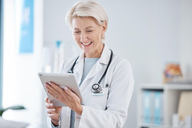 Foto tableta de atención médica y médico senior sonríen en el hospital para consultar en línea telesalud y aplicación de bienestar seguro clínico y mujer en tecnología digital para investigación médica en internet o datos de pacientes