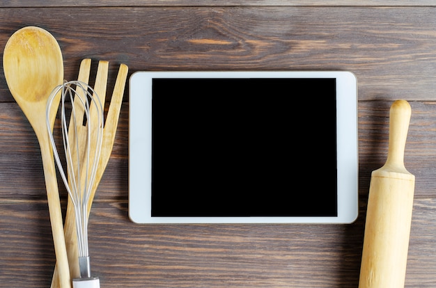 Una tableta y batería de cocina en una madera marrón