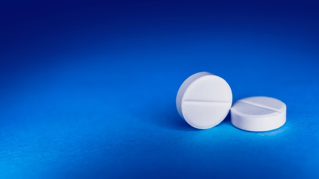 Tableta blanca sobre fondo azul. preparaciones medicinales
