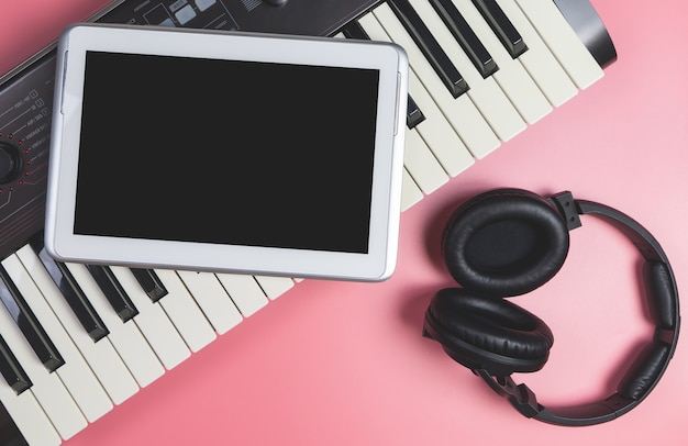 Tableta en blanco en el teclado de estudio para simulacro de aplicación de música