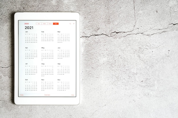 Una tableta con un calendario abierto para el año 2021 en un gris.
