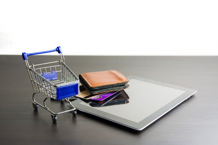 Foto tableta con carrito de la compra en madera.