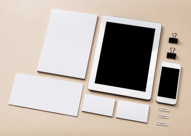 Tableta digital con móvil y papeles sobre la mesa en la oficina