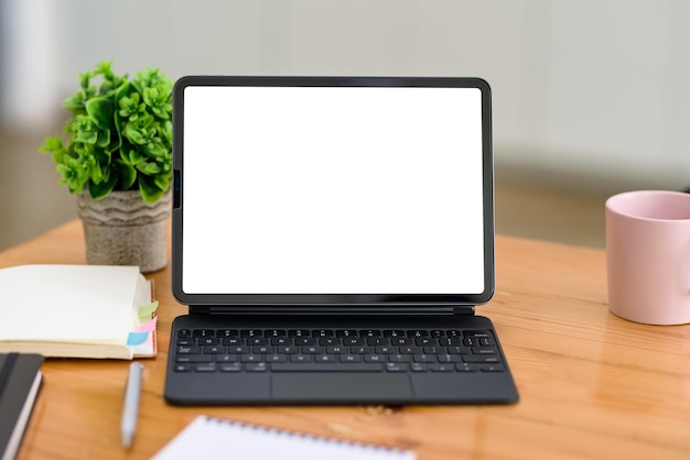 Tableta digital pantalla en blanco con teclado en la mesa de madera. Bosquejo.