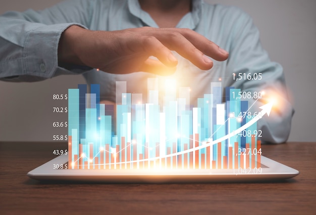 Tableta de holding empresario con gráfico y gráfico de holograma de estadística virtual.