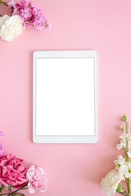 Tableta ipad pro con pantalla blanca sobre fondo de color rosa flores oficina diseño fondo de mujer