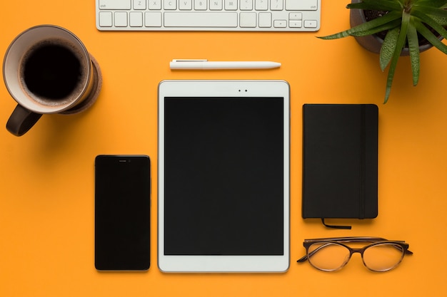 una tableta con una libreta, un bolígrafo, gafas y un teléfono inteligente