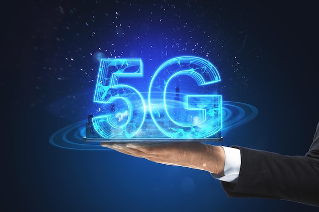 Tableta de mano de hombre de negocios con holograma 5G brillante creativo sobre fondo azul Conexión de velocidad de Internet y concepto de servicio