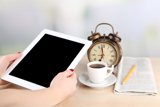 Tableta taza de café y reloj despertador de cerca