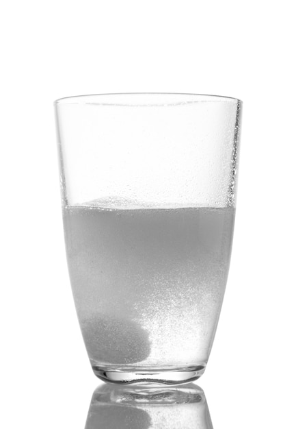 Tableta en un vaso de agua sobre un fondo blanco.