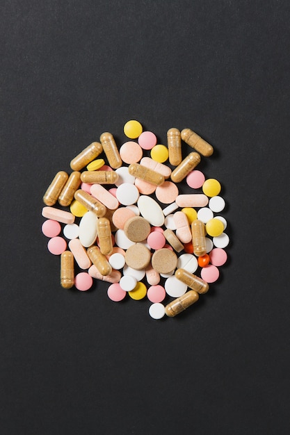 Tabletas redondas coloridas blancas de medicación dispuestas abstractas sobre fondo de color rojo
