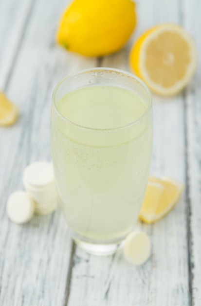 Foto tabletas de vitamina c sobre fondo de madera enfoque selectivo