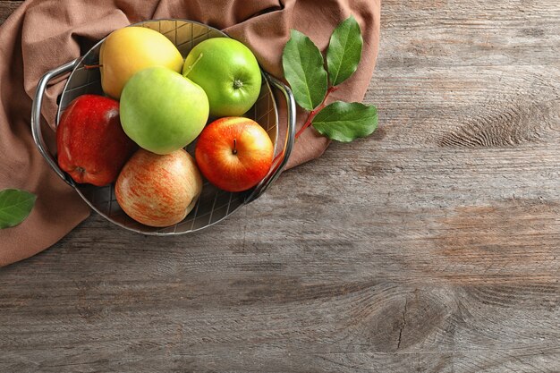 Tablett mit reifen saftigen Äpfeln auf Holztisch, Ansicht von oben