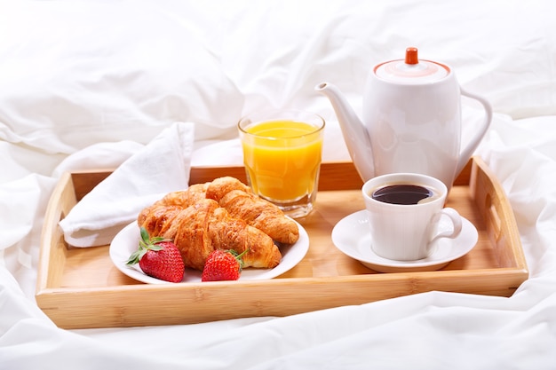 Tablett mit Tasse Kaffee und Croissants