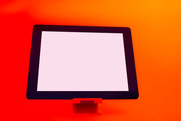 Tablette mit weißem Bildschirm. Mockup gegen helles, rotes kreatives Licht.