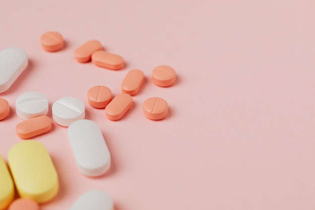 Tablettenfläschchen verschüttet. bunte pillenkapsel auf oberflächentabletten auf rosa hintergrund