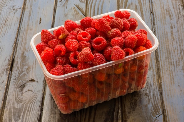 Tabletts mit Himbeeren auf einem hölzernen Hintergrund