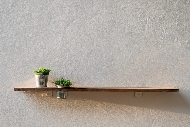 Tablón de madera en la pared con planta de florero