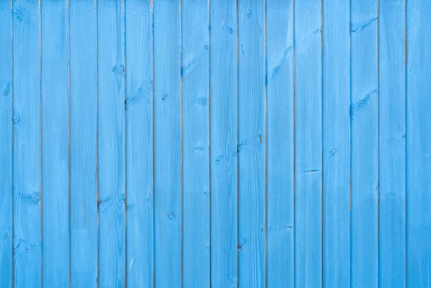 Tablones de madera antiguos cubiertos con pintura azul escamosa. Textura de madera.